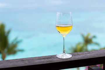 Glass of white wine on balcony rail