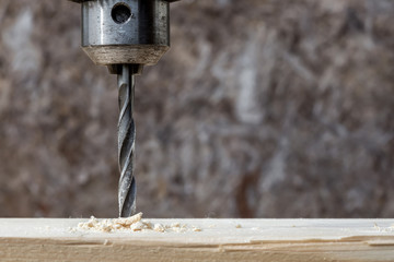 Drilling wooden plank with hand drill