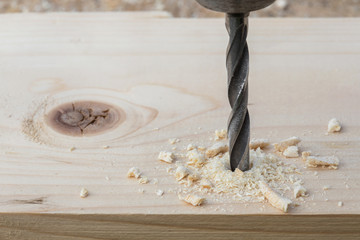 Drilling wooden plank with hand drill