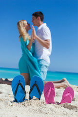 Fototapeta premium Slippers in sandy beach, travel concept