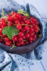 Ripe red currant in wooden bowl