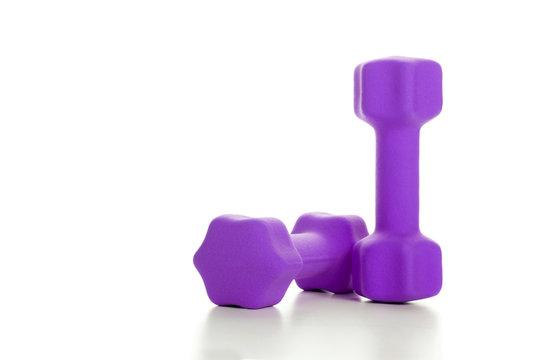 Fitness concept with two purple dumbbells on white background
