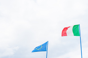 Italian and european community flag on cloudy sky