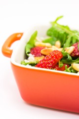 Fresh salad with arugula, strawberries, parmesan and pine nuts
