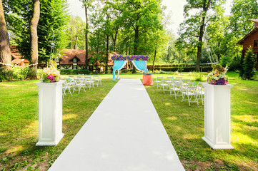 Beautiful wedding arch with flowers in garden / All is ready for a wedding ceremony in the garden in sunny day - 91707500