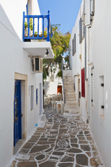 Street with traditional architecture and decorated cobble stone pavement in Naousa village on Paros island, Greece