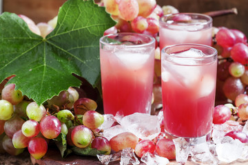 Cool pink grape juice with ice, selective focus
