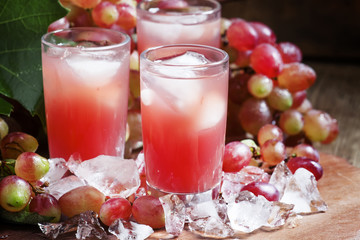 Cool pink grape juice with ice, selective focus