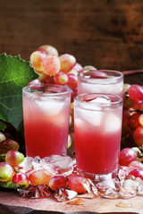 Cool pink grape juice with ice, selective focus