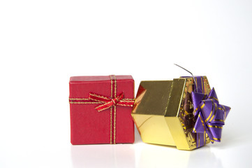 Gift boxes, one red and one golden with violet bow, isolated on white background.