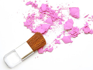 Cosmetic powder brush and crushed powder on white