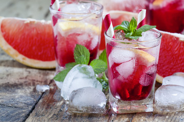 Grapefruit Cocktail with ice in a small glass on old wooden tabl