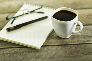 Obraz na płótnie Canvas black coffee and notebook on the table