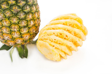 Fresh juicy nutritious cut pineapple with whole fruit as background