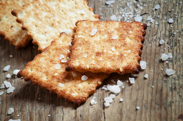 Salty cracker and sea salt on a dark wooden background, toned im