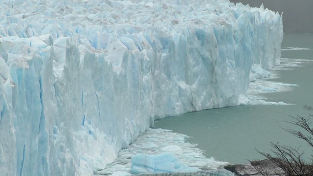 The front of a glacier is crumbling into the sea.