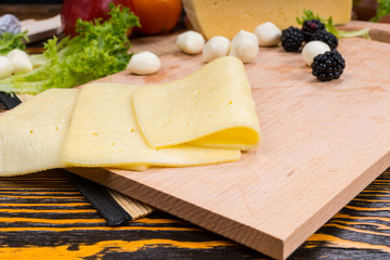 Sliced Cheese on Wood Board with Blackberries
