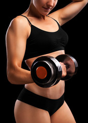 Athletic girl with dumbbells in hand.