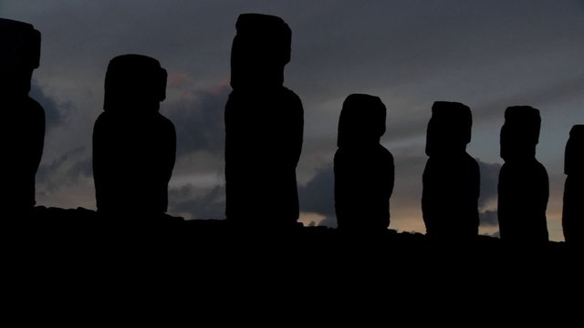 A pan across Easter Island statues at dusk.