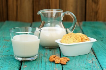 Homemade fresh almond milk in glass jar and glass bowl, with hom