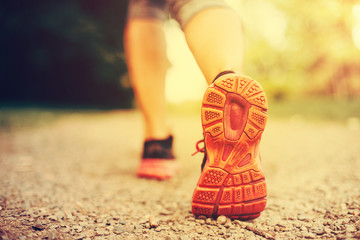 Woman runner feet running closeup and selective focus on shoe