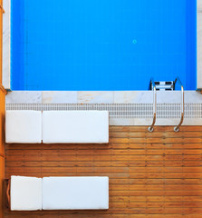 Top view of sunbeds near private pool