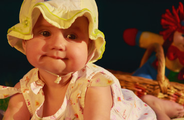 Adorable baby girl lying on green summer lawn