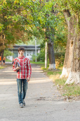Obraz premium young student man holding a book and tablet against a city background