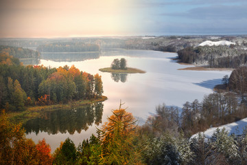 Fototapeta na wymiar Lake Jedzelwo in autumn and winter. Composition fifty fifty. Masuria, Stare Juchy, Poland.