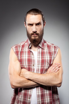 Attractive young man with beard is serious