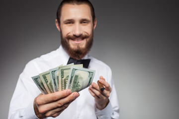 Attractive young man with dollars is smoking