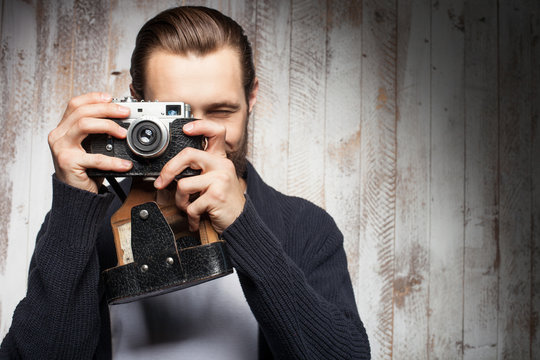 Attractive young bearded man is photographing something 