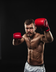 Athletic bearded boxer with gloves on a dark background - 91733574