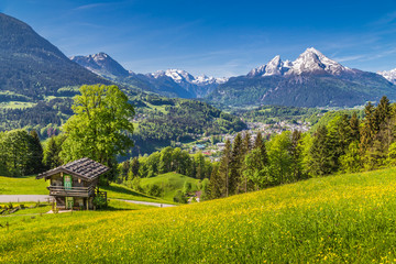 Idyllic landscape in the Alps with traditional mountain lodge in springtime