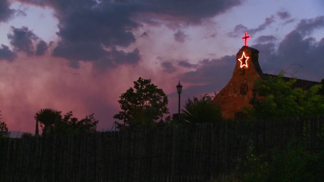An adobe church at dusk.