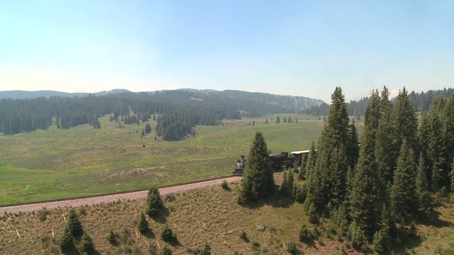 A steam train passes through the Rocky Mountains.