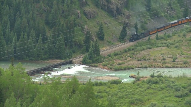 High angle of a steam train traveling through a canyon.