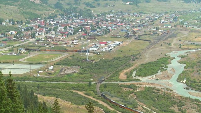 A very distant shot of a steam train arriving in Silverton, Colorado.