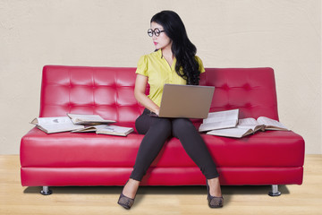 Student sitting on sofa while doing homework