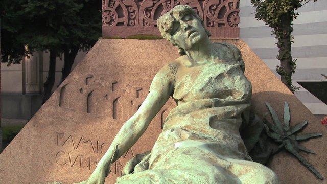 A sculpture in a cemetery seems to be suffering.