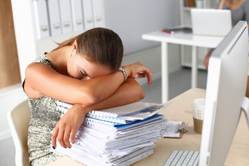 An exhausted businesswoman passed out at her desk .