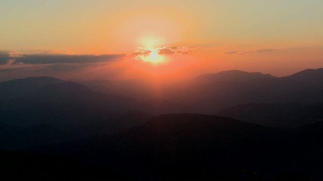 Medium-shot of a fiery sunset over a generic mountain range.