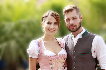 Glückliches bayrisches Paar in Tracht mit Bier und Brezn