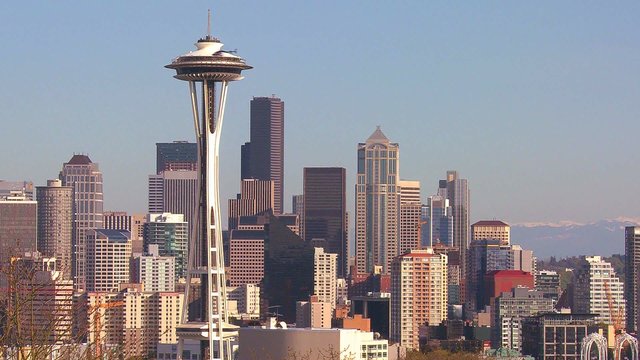 Beautiful establishing shot of Seattle Washington on a sunny day with a helicopter flying by.