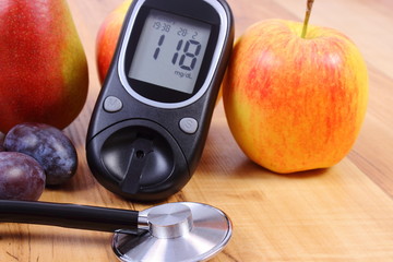 Glucose meter with medical stethoscope and fresh fruits, healthy lifestyle