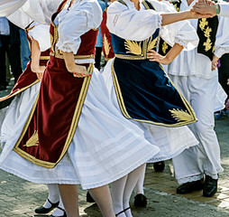 Dancers in traditional costumes who perform the movements of a serbian dance.