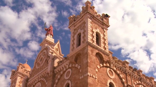 A time lapse pull back as clouds drift over a Catholic Maronite Church.