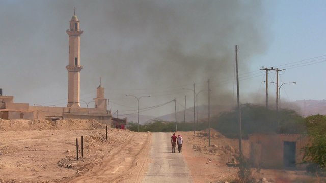 A fire burns on a lonely road near a mosque in the Palestinian Territories.