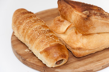 Hot dog bun and pastry on the wooden board