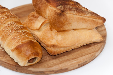 Hot dog bun and pastry on the wooden board